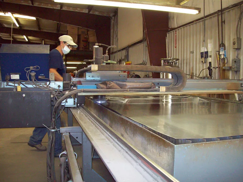 A WATCO fabrication operator working with sheet metal in the company shop